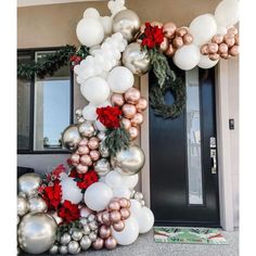 a christmas wreath made out of balloons and poinsettis on the front door