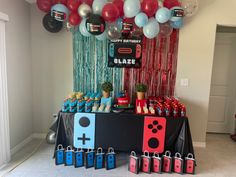 a party table with balloons and decorations for a video game themed birthday or baby shower