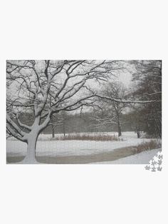 a snow covered field with a tree in the foreground and puzzle pieces on the ground