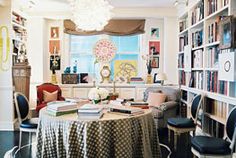 a dining room table surrounded by chairs and bookshelves