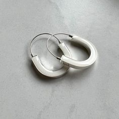 These lovely big hoop earrings are easy to wear and are light as a feather. How to Open and Close:  Locate the small opening that is only on one side of the earring.  Gently pull towards you and outward from either side of the opening. The earring will open. The wire will exit from the little hole and its tension will secure the lock when closing. Design 2017. Details: - Name: You Earrings - 35 mm wide - 45 mm long - 3 mm thick - 925. Silver mark and '' iv'' maker's mark - Sterling silver and resin - White pigment Care info: Please see my FAQ for further information regarding materials, finishes, and their care. © Ivavvi Studio Big Silver Earrings, Silver Earrings Long, White Jewellery, Earrings Big, Big Hoop Earrings, Earrings White, White Jewelry, Black Jewelry, Big Earrings