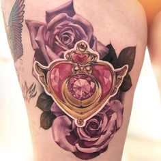 a woman's thigh with tattoos on it and a heart shaped diamond in the center