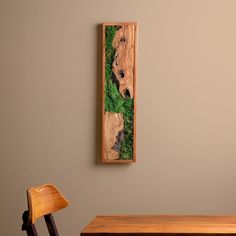 a wooden table with two chairs and a painting on the wall