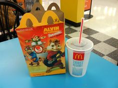 a plastic cup with a straw next to a box of cereal