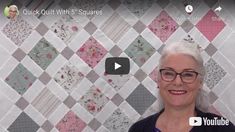 a woman standing in front of a quilt