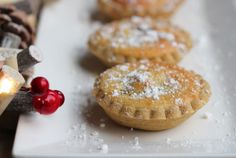 several pastries are sitting on a white plate next to some pine cones and candles