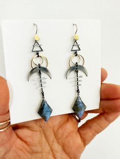 These cosmic sign earrings are rich with cosmic symbols - earth element, solar eclipse, and crescent moon - that together help with emotional balance and to protect against negative energies.  The diamond shaped labradorite is an additional layer of protection. It fills our aura with positivity, giving us the emotional strength and will to go through difficult spiritual transformations. I oxidize and hand finish some of the sterling silver elements to bring out contrast, and achieve an ombre eff Spiritual Crescent Nickel-free Earrings, Modern Crescent Jewelry For Pierced Ears, Symbolic Crescent Moon Charm Earrings, Unique Moon Phase Earrings For Gift, Unique Adjustable Earrings With Moon Charm, Unique Sun And Moon Design Earrings As Gift, Unique Moon Charm Round Earrings, Symbolic Moon Phase Dangle Earrings, Symbolic Crescent Earrings