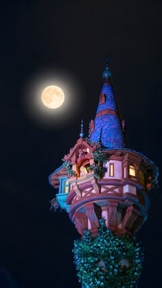 a full moon shines in the night sky above a building with turrets and windows