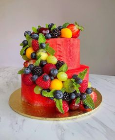 a three tiered cake with fruit on top