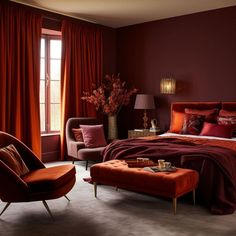 a bedroom decorated in red and orange with a bed, chair, ottoman, coffee table and window