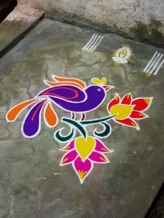 a colorful bird painted on the ground in front of a table with utensils