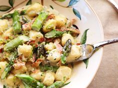 a white bowl filled with pasta and vegetables