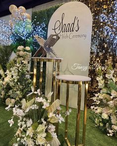 two tables with flowers on them in front of a sign that says shad's high ceremony