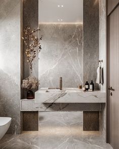 a bathroom with marble walls and flooring in grey tones, including a large mirror above the sink