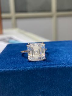 an emerald colored diamond sits on top of a blue box