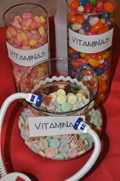 there are many different types of candies in the glass bowls on the table with name tags