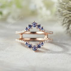 an open ring with blue sapphires and diamonds in it on top of a table