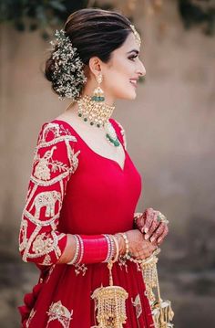 a woman wearing a red dress and jewelry