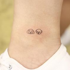 a small dog and cat tattoo on the ankle