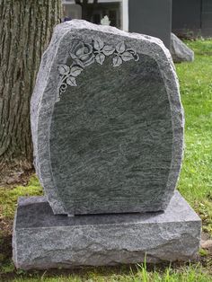 a large stone with flowers on it sitting in the grass