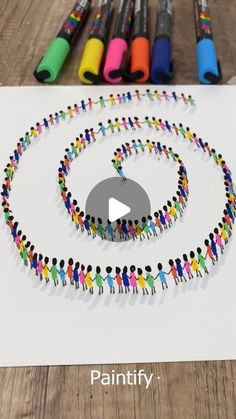 a group of people standing in the shape of a circle with marker pens around them