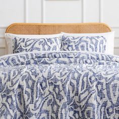 a bed with blue and white comforter on top of it