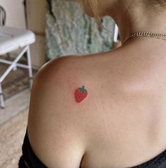 a woman with a small strawberry tattoo on her back