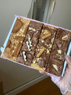 a person holding a box filled with brownies and nuts