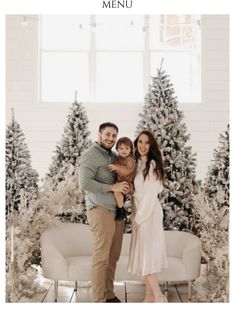 a man and woman standing in front of christmas trees