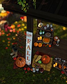 a halloween display with pumpkins, candles and other decorations on the grass in front of a sign that says happy fall