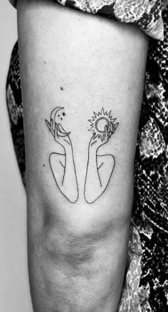 a woman's arm with two small sunflowers on the left side of her arm