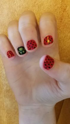 a woman's hand with red and black polka dots on it