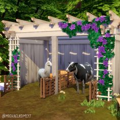 two cows standing next to each other in a fenced off area with purple flowers