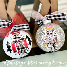 two decorated christmas ornaments sitting on top of a table