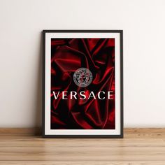 a red poster with the word versa on it in front of a white wall and wooden floor