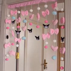 a door decorated with pink, blue and white heart - shaped decorations hanging from it's side