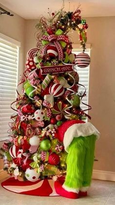 a christmas tree decorated with candy canes, ornaments and green fur trimmings