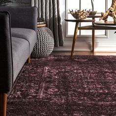 a living room area with a couch, chair and rug on the floor in front of a window