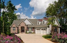 a large house with lots of flowers in the front yard