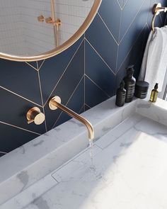 a white sink sitting under a mirror next to a faucet