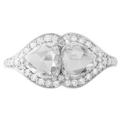 This twin stone or 'Toi et Moi' ring features a beautifully matched pair of rose cut pear shape diamonds weighing 2.23 carats total. The diamonds 100% natural and approximately F to G color and VS clarity. The stones are set in a beautiful platinum pavé mounting. The rose cut is an antique cut that dates back to the 16th century. The cut has a flat bottom and a domed top, with triangular facets that resemble the petals of a rose, hence the name. The result is a diamond that has a soft and romantic glow, making it a popular choice for antique-inspired jewelry. This ring is a size 6, but can be resized easily and quickly at no cost. Made in New York. Antique Inspiration, Inspired Jewelry, Pear Shaped Diamond, Rose Cut Diamond, 16th Century, The Rose, A Rose, Pear Shape, Cocktail Rings