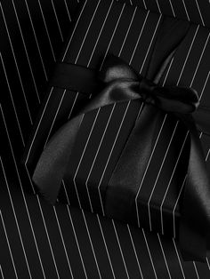 a black and white striped suit with a satin bow tie on the lapel cover