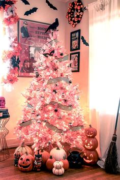 a pink christmas tree decorated with black and white striped ribbon, pumpkins and bats