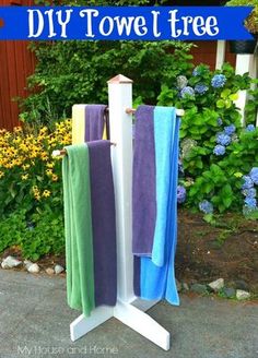 three towels are hanging on a towel rack in front of some flowers and bushes with the words diy towel tree