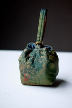 a small green bag sitting on top of a white table