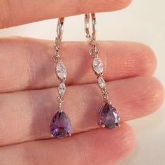 Theses Beautiful Purple Water Drop Hoop Pierced Earrings Are Made Of 18k White Gold Filled With (Lab Created) Purple And White Topaz Zircon Stones. Brand New, Never Been Worn. These Fine Quality Earrings Are Perfect For Everyday Wear Or A Special Gift. Get An $18 Gift Of Your Choice In My Listings W/Purchase Of Two Or More Items. Please Send Offers And Questions. Earrings: 37x6mm Or 1.47 X .24" Large Pear Shape Stone: 6x8mm Or .34" X .31" Hoop Diameter: 11mm Or .43" Silver Opal Earrings, Silver Crystal Earrings With Lever Back For Anniversary, Silver Earrings For Prom, Light Purple Earrings, Lilac Jewelry, Purple Stone Earrings, Crystal Wedding Earrings, Purple Drop Earrings, Sliver Earrings