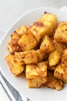 a white plate topped with fried potatoes on top of a table