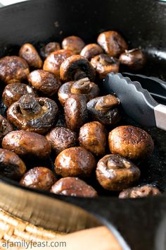 mushrooms being cooked in a skillet with a spatula