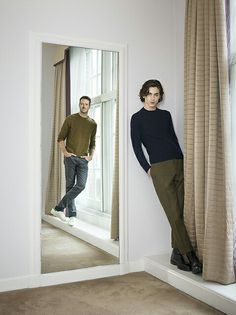 two men are standing in front of a mirror