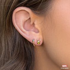 a close up of a person wearing an earring with two small stones on it